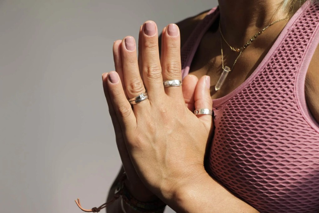 Kitia in prayer hands mudra, crystal pendant visible